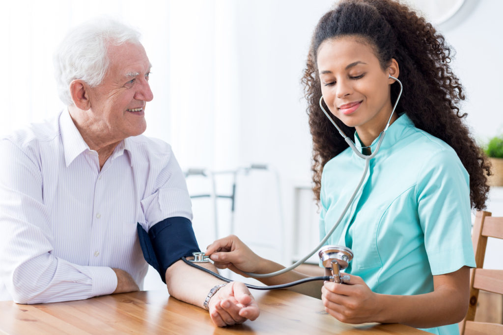 Professional nurse checking patient's blood pressure
